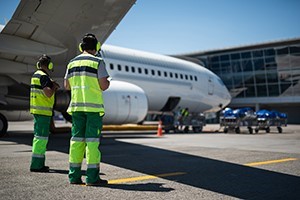 Workers standing next to an airplane at an airport